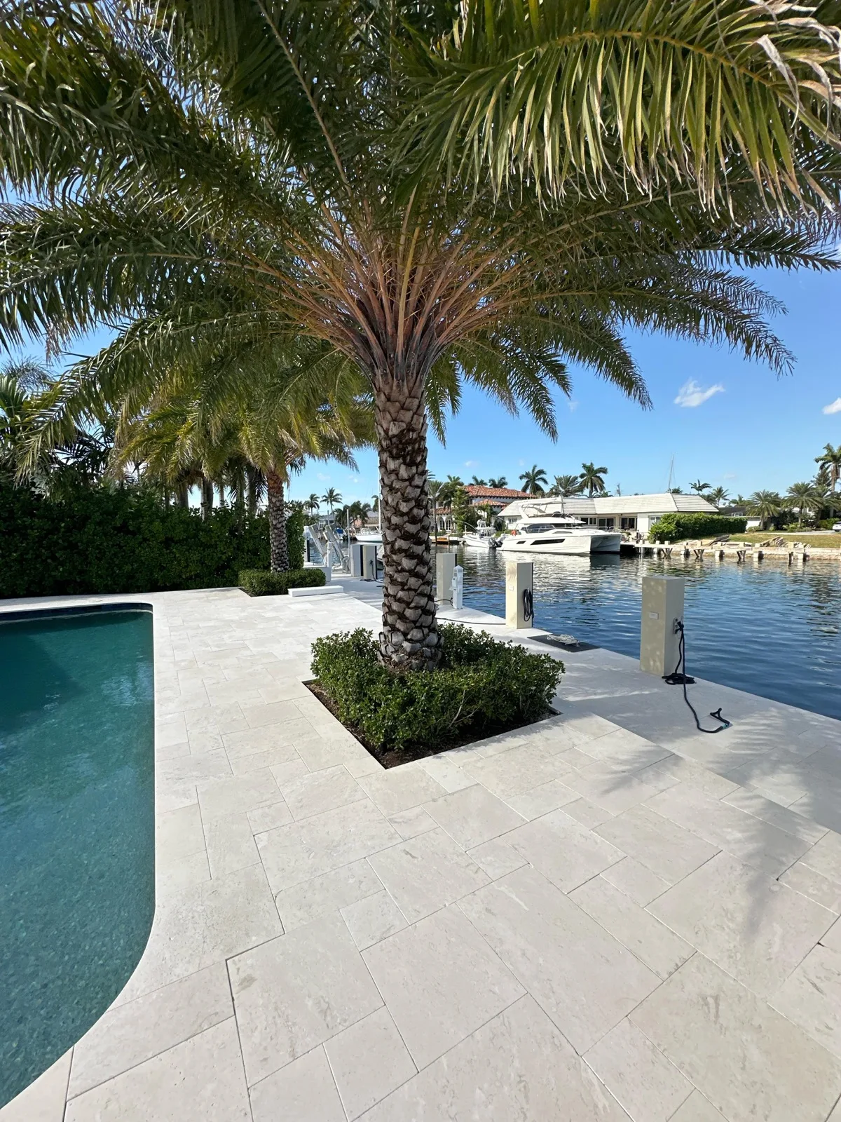 Manicured waterfront pool patio and landscaping on a Lighthouse Point property