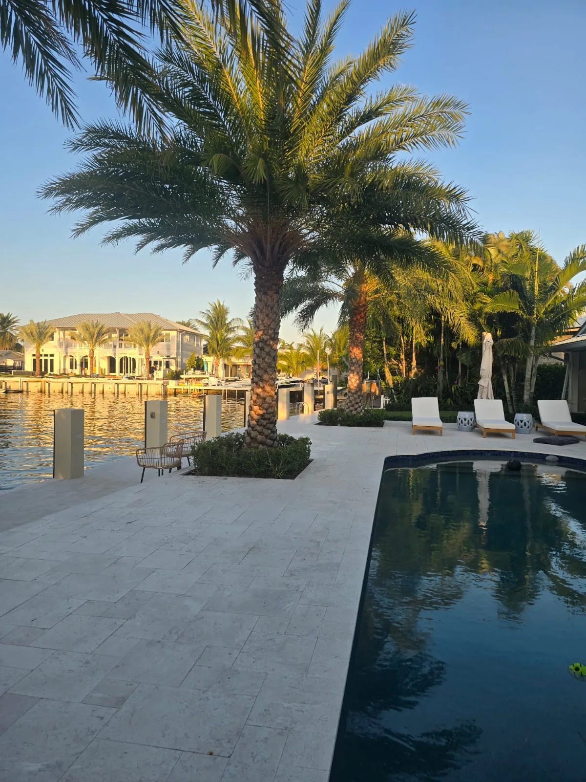 Waterfront lawn and pool at sunset in the Lighthouse Point area